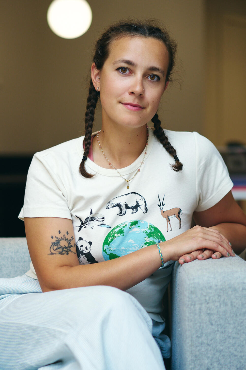 Indiemoon Illustrator Indiemoon the illustrator sits in a chair with her hands cupping on the side of the chair